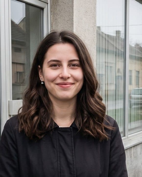 Portret mlade žene tamne talasaste kose ispred izloga