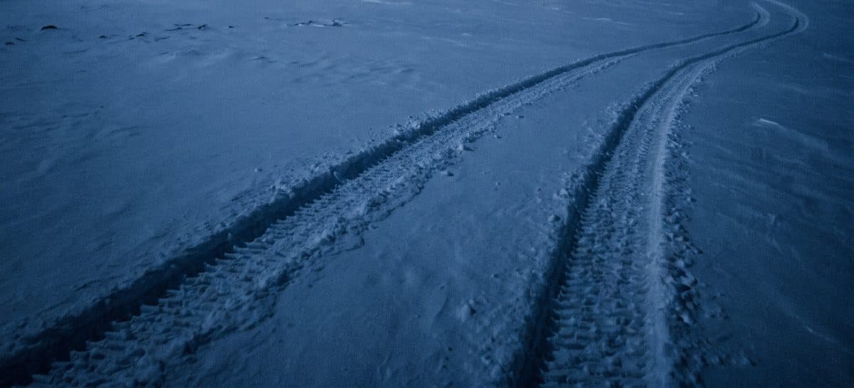 Dva traga gusenica u dubokom snegu nestaju u mećavi